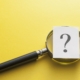 Magnifying glass with question mark on yellow